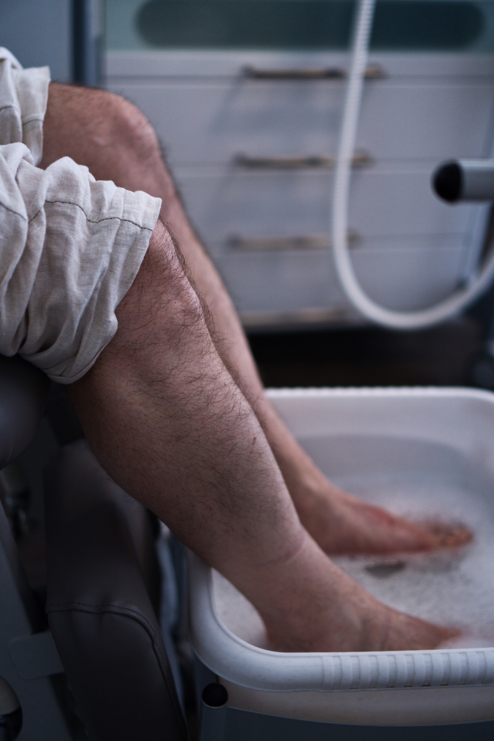 Männlicher Patient genießt ein Fußbad vor der podologischen Behandlung.