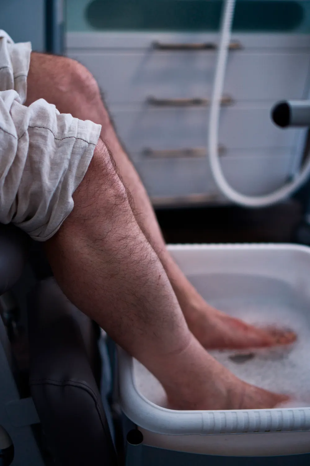 Männlicher Patient genießt ein Fußbad vor der podologischen Behandlung.