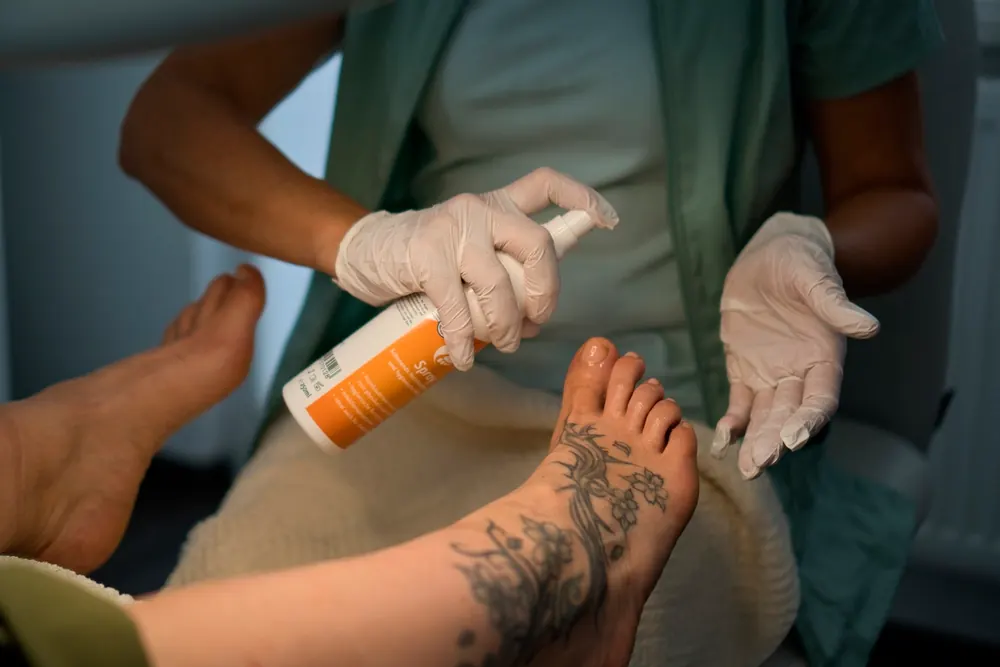 Pflegecreme wird nach der Behandlung in den Fuß einmassiert.